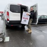 A toys for Tots representative loading boxes into a van